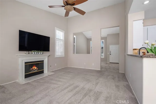 a view of an empty room with fire place and a window