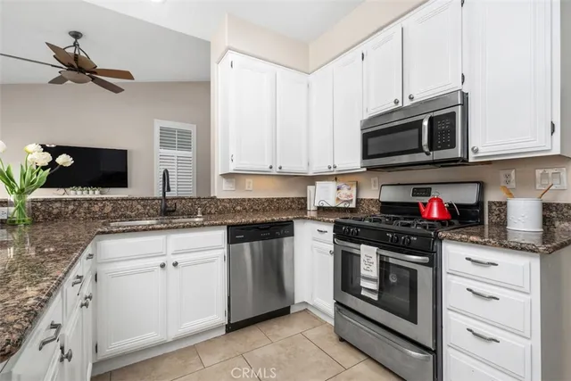 a kitchen with stainless steel appliances granite countertop a sink and a stove