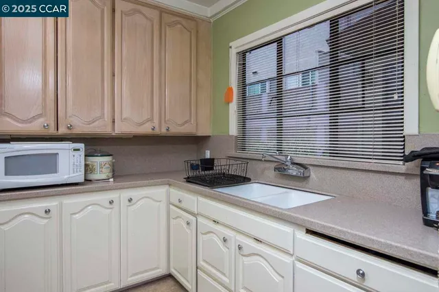 a kitchen with granite countertop white cabinets and white appliances