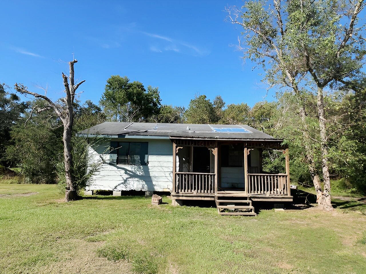 a view of a house with backyard sitting area and garden