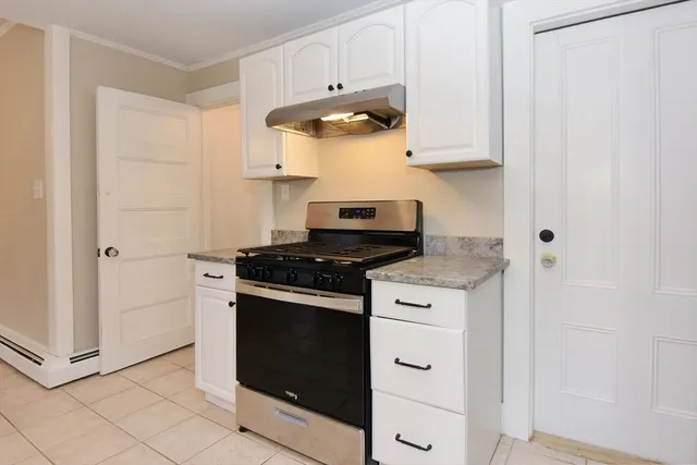 a kitchen with white cabinets and appliances