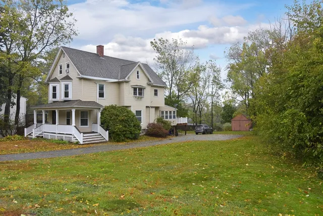 a view of a house with a big yard and large trees