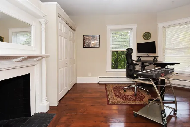a living room with wooden floor windows and a flat screen tv