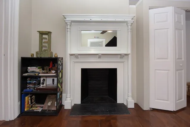 a living room with a fireplace and a wooden floor