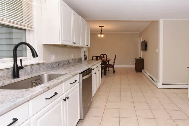 a kitchen with granite countertop a stove a sink and a counter top space