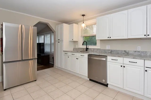 a kitchen with white cabinets and white appliances