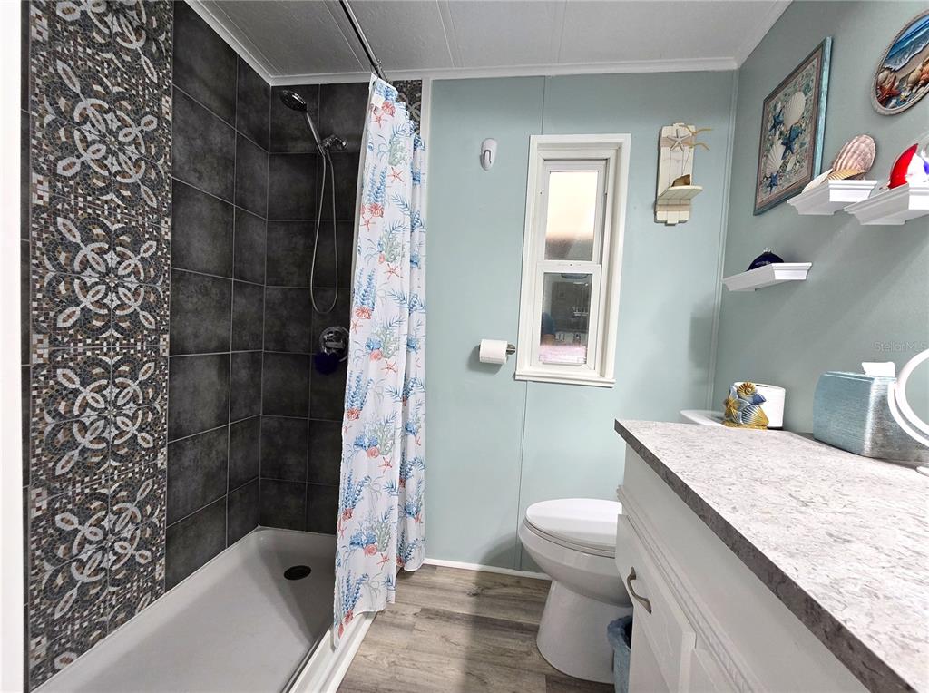 5619 Bayshore Road, Unit 435 Palmetto, FL 34221 - Photo 21 of 56 a bathroom with a granite countertop sink a toilet and shower