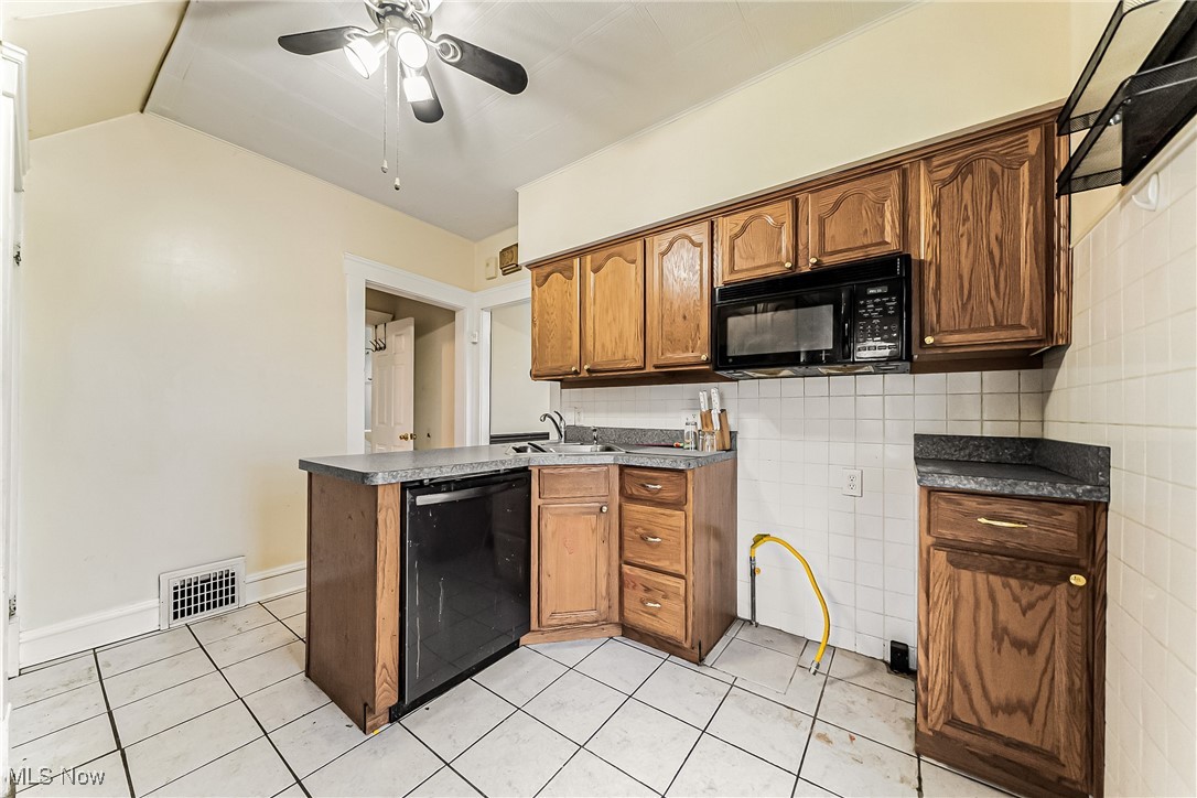 2014 Cook Avenue Cleveland, OH 44109 - Photo 10 of 37 Kitchen featuring sink, light tile patterned floors, tile walls, and black appliances
