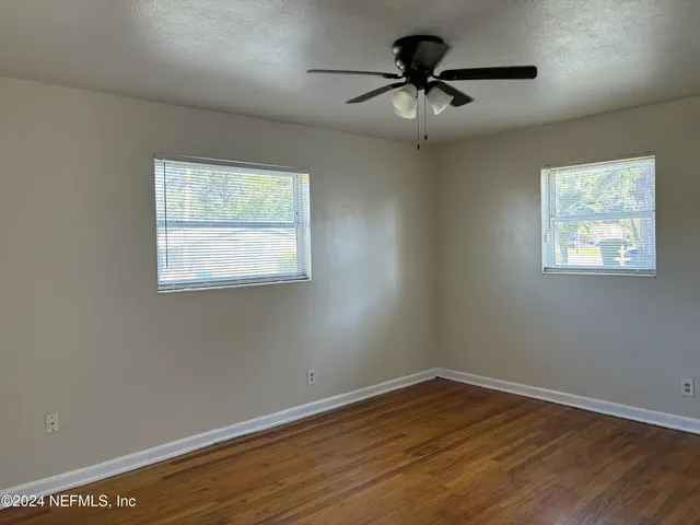 a view of a room with wooden floor and windows