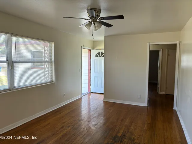 a view of a livingroom with a chandelier fan and a window