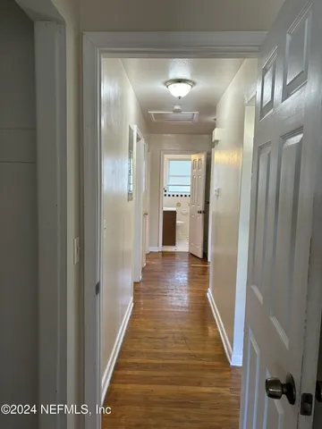 a view of a hallway with wooden floor
