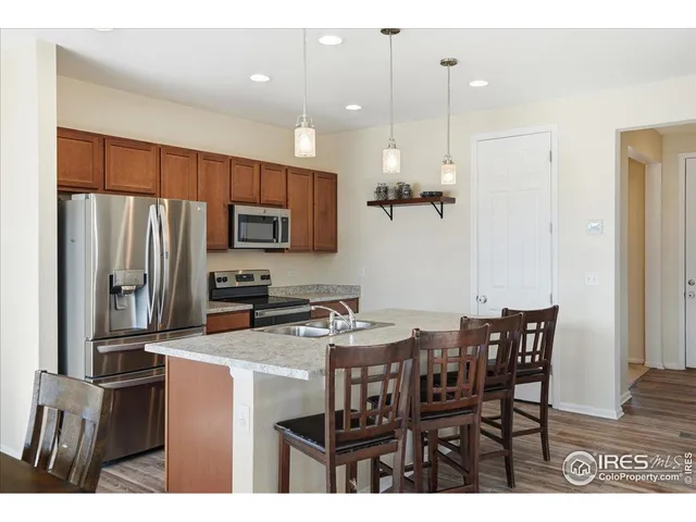 a kitchen with kitchen island a refrigerator and a sink