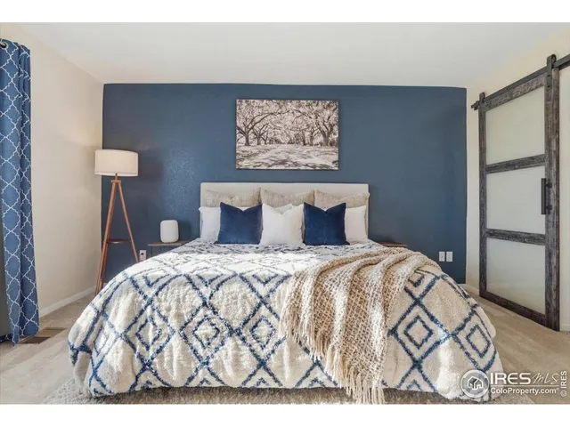 a bedroom with a bed and a wall painting