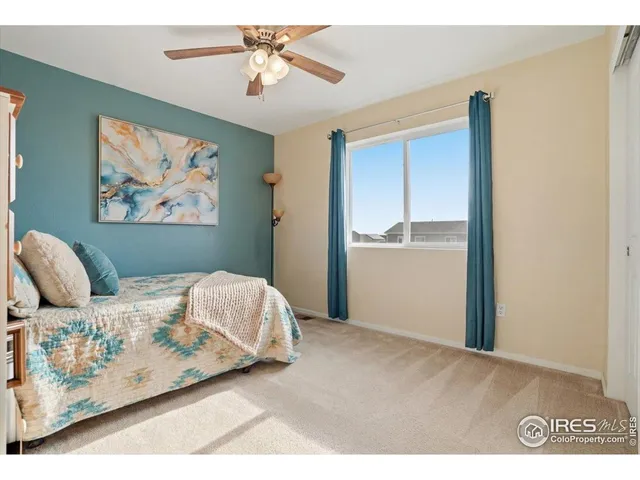 a bedroom with a bed and a painting on the wall