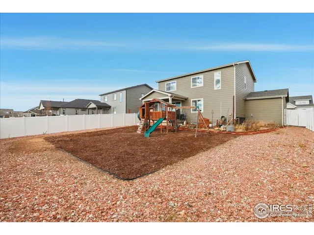a backyard of a house with barbeque oven a table and chairs