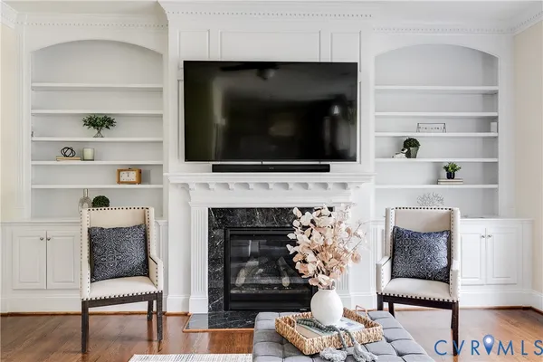 a living room with furniture a fireplace and a flat screen tv