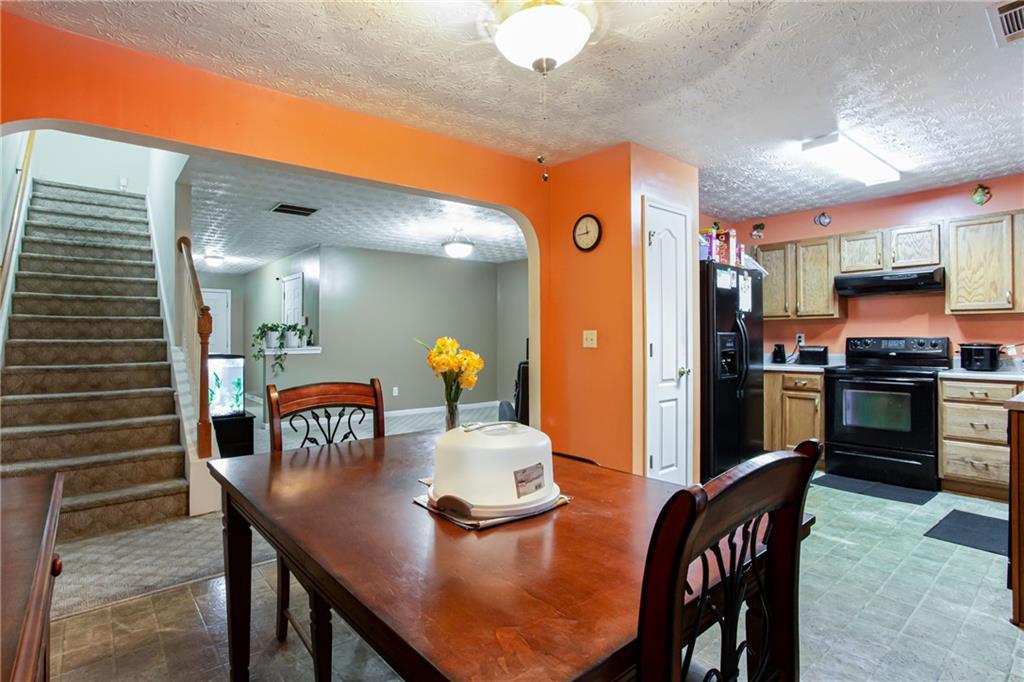 690 Georgetown Lane Jonesboro, GA 30236 - Photo 16 of 30 a kitchen with stainless steel appliances granite countertop a sink a stove a refrigerator cabinets and chairs