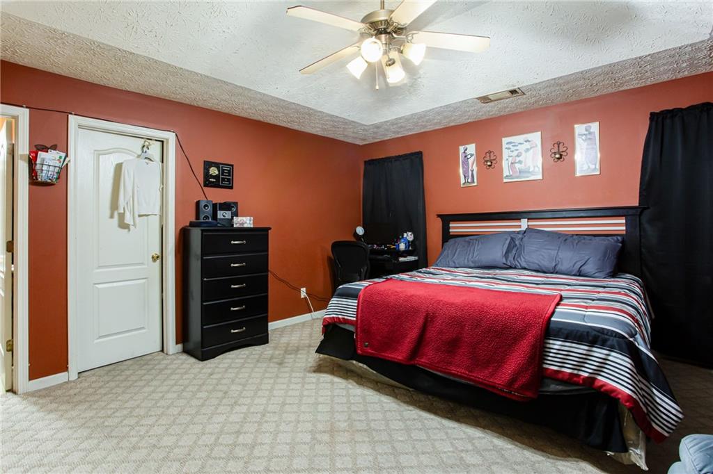 690 Georgetown Lane Jonesboro, GA 30236 - Photo 22 of 30 a bedroom with a bed and a chandelier