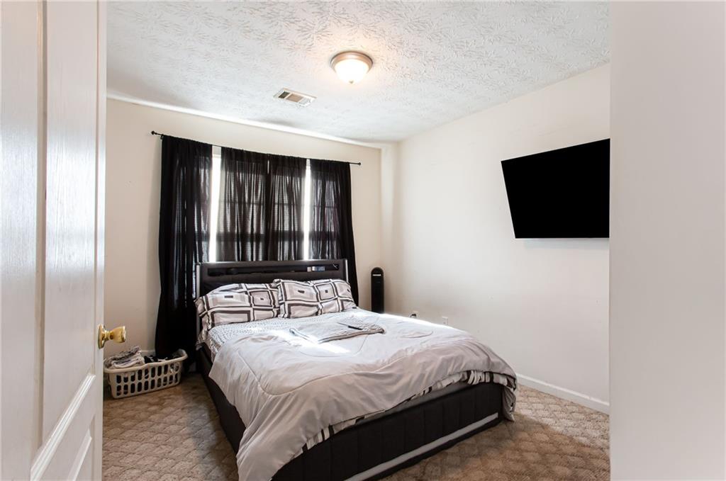 690 Georgetown Lane Jonesboro, GA 30236 - Photo 28 of 30 a bedroom with a bed and a flat tv screen on dresser