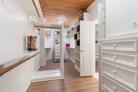 a hallway with white cabinets and wooden floor