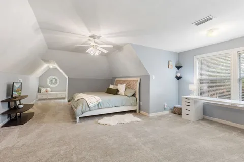 a spacious bedroom with a bed and a large window