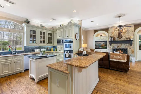 a large kitchen with granite countertop a sink and a stove top oven