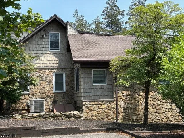 a front view of a house with a tree