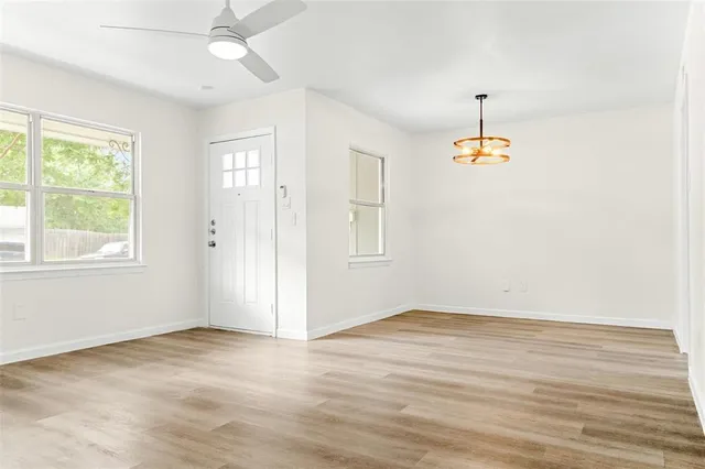 an empty room with wooden floor and window