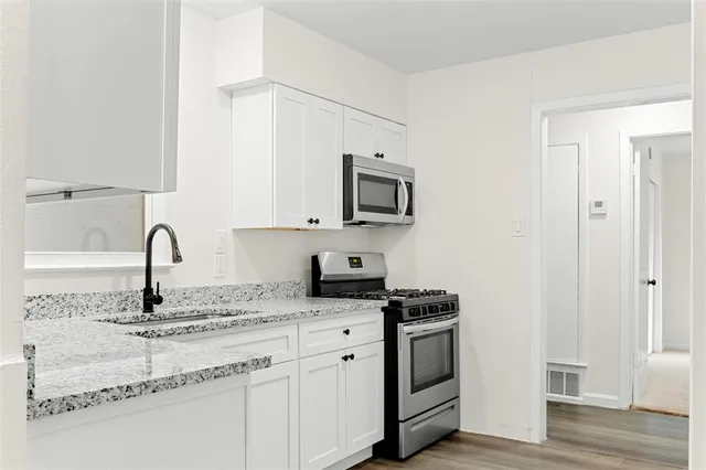 a kitchen with granite countertop white cabinets and appliances