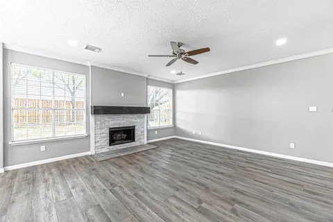 a view of empty room with wooden floor and fireplace