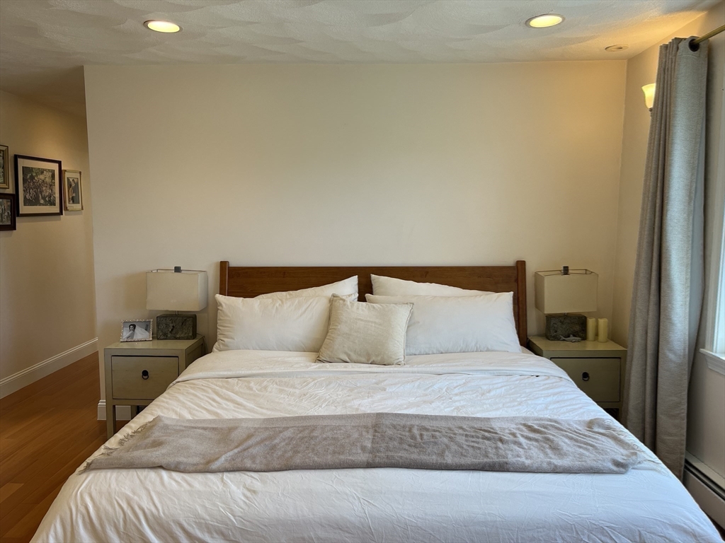 11 Garrison Road, Unit 1 Arlington, MA 02474 - Photo 28 of 42 a bedroom with a bed and wooden floor