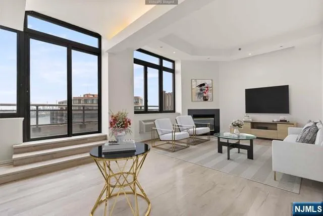 a living room with furniture a flat screen tv and a large window