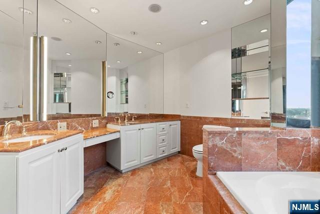 100 Carlyle Drive, Unit PHDN Cliffside Park, NJ 07010 - Photo 26 of 39 a bathroom with a tub a sink double vanity and a mirror