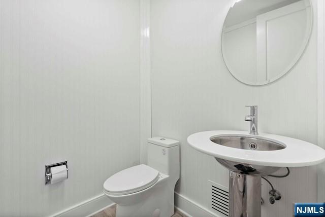 100 Carlyle Drive, Unit PHDN Cliffside Park, NJ 07010 - Photo 35 of 39 a bathroom with a sink a toilet and a mirror