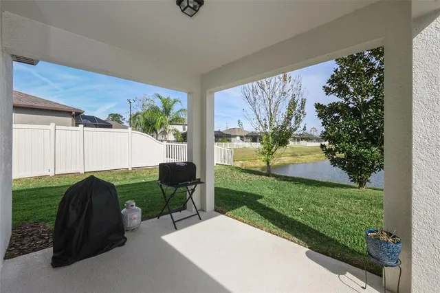 a view of a swimming pool with lawn chairs and a big yard