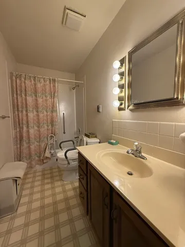a bathroom with a double vanity sink toilet and mirror
