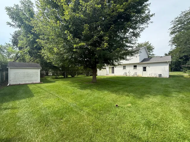 a front view of a house with a yard and trees