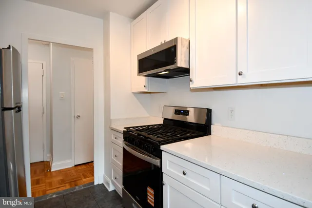 a kitchen with stainless steel appliances white cabinets and a stove