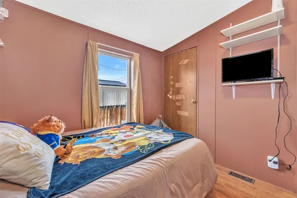 a bedroom with a bed and a flat screen tv