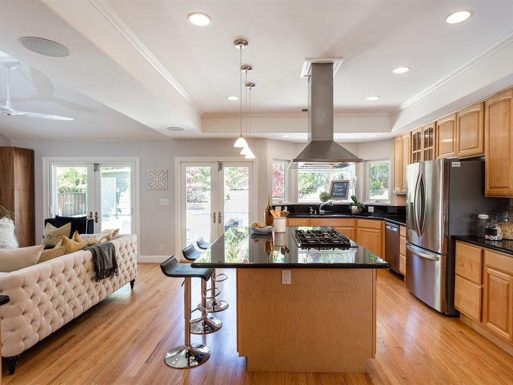 10 Kenton Avenue San Carlos, CA 94070 - Photo 11 of 25 a kitchen with stainless steel appliances granite countertop a refrigerator a stove and a dining table with wooden floor