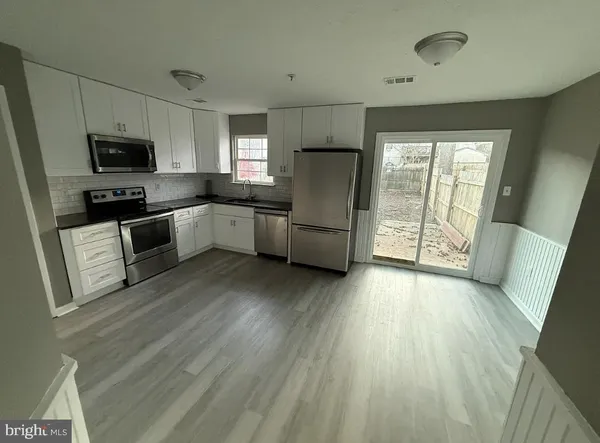 a kitchen with stainless steel appliances a refrigerator sink and microwave