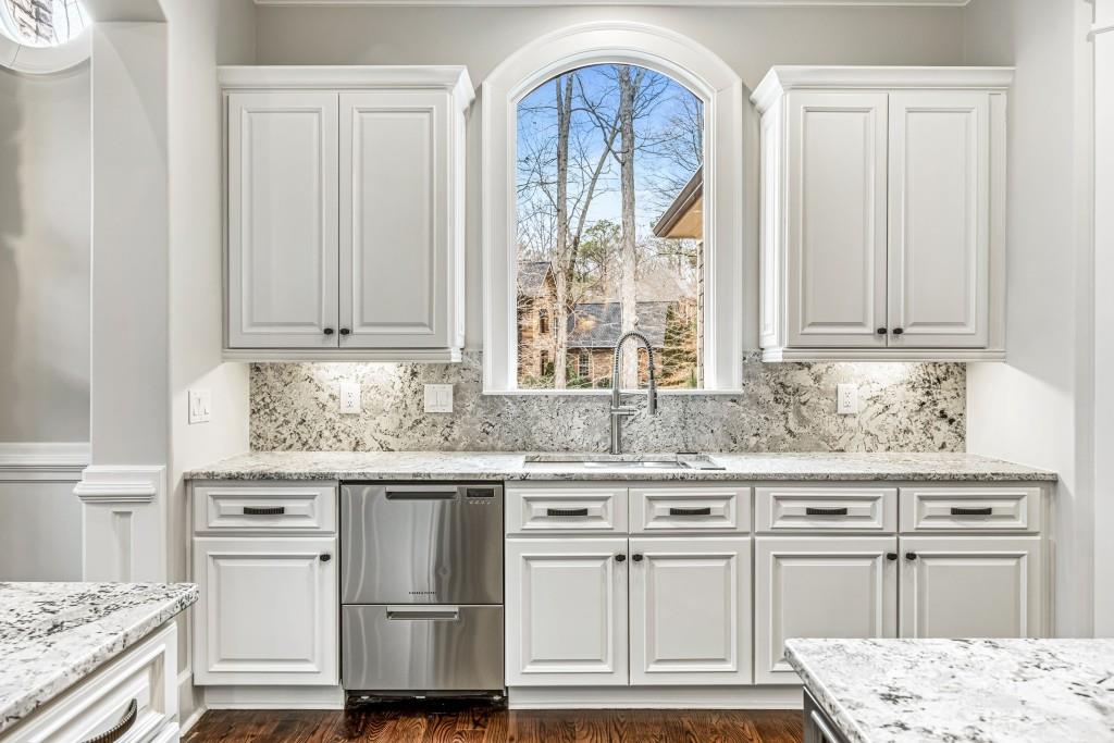 47 Fern Leaf Way Newnan, GA 30265 - Photo 8 of 65 a kitchen with stainless steel appliances granite countertop a stove a sink and white cabinets with wooden floor