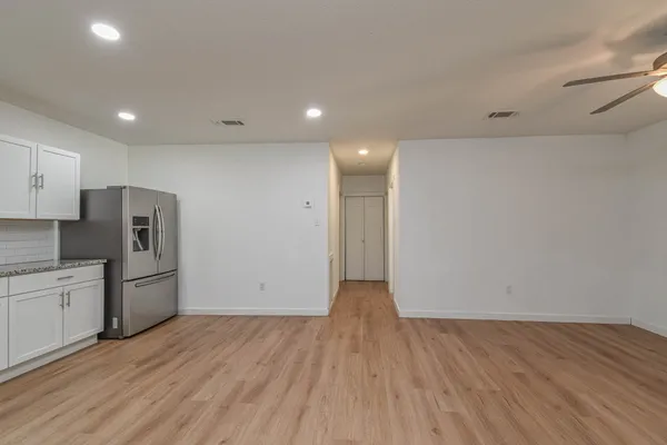an empty room with wooden floor and window
