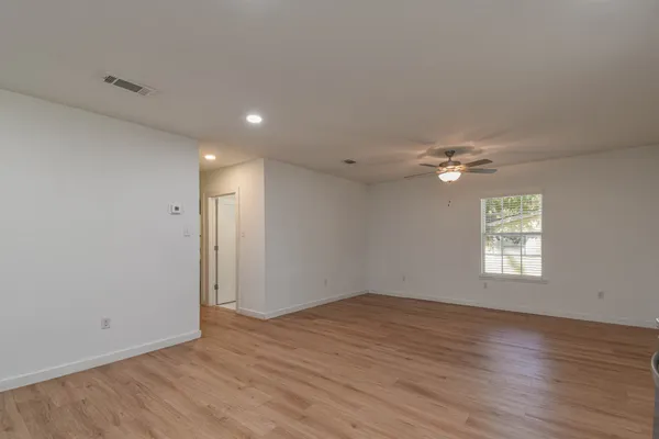 a kitchen with stainless steel appliances granite countertop a sink cabinets and wooden floor