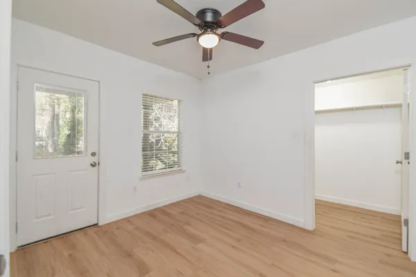 a view of an empty room with window and wooden floor