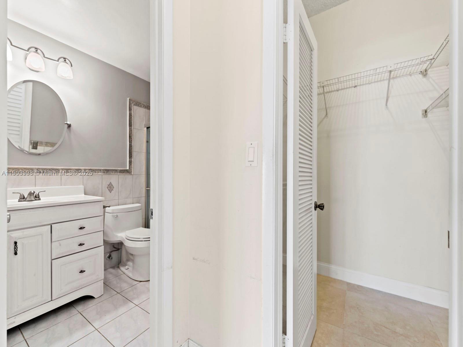 19233 Northwest 64th Court Hialeah, FL 33015 - Photo 16 of 34 a bathroom with a double vanity sink a toilet and a mirror