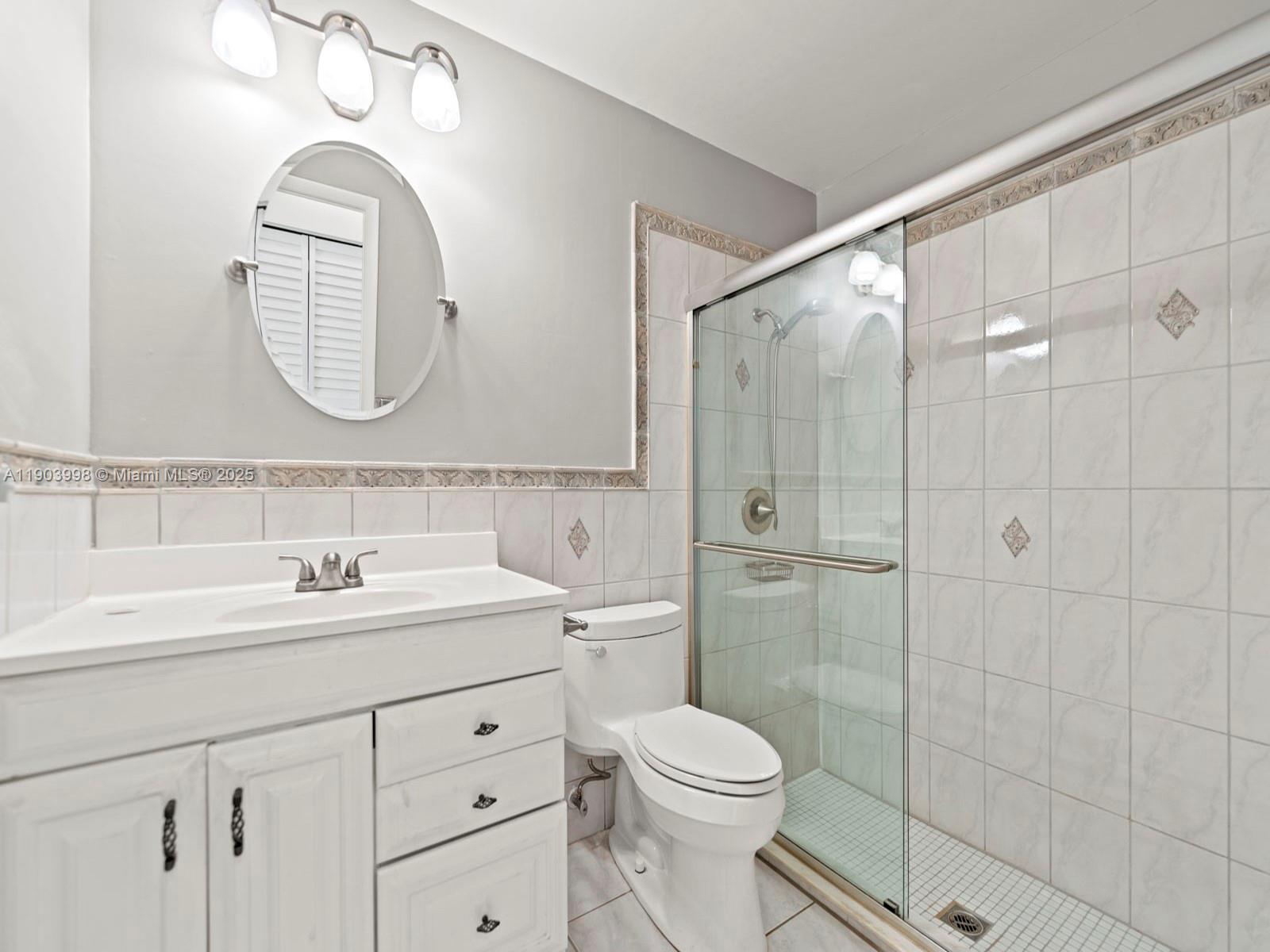 19233 Northwest 64th Court Hialeah, FL 33015 - Photo 17 of 34 a bathroom with a toilet a sink a mirror and a shower