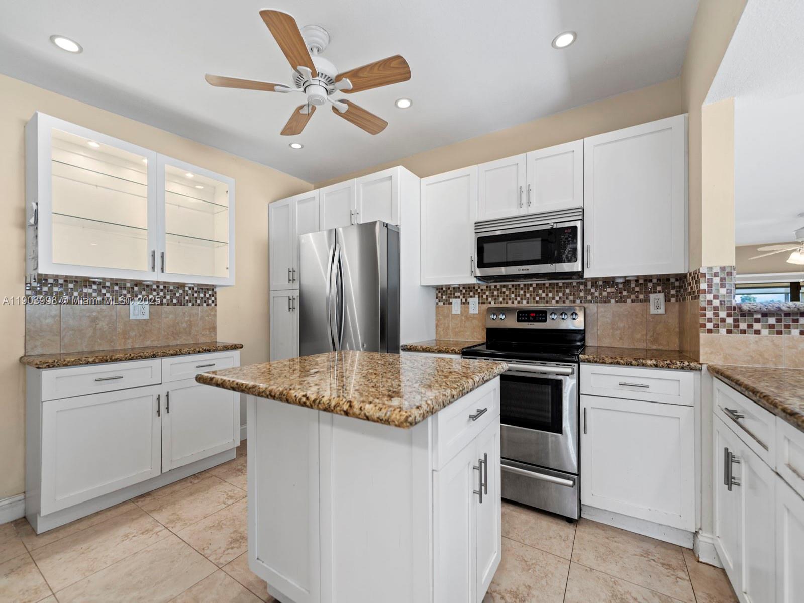 19233 Northwest 64th Court Hialeah, FL 33015 - Photo 19 of 34 a kitchen with kitchen island granite countertop appliances cabinets and a sink