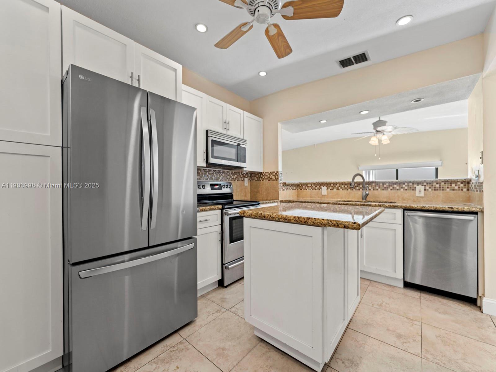 19233 Northwest 64th Court Hialeah, FL 33015 - Photo 22 of 34 a kitchen with stainless steel appliances a refrigerator sink and cabinets