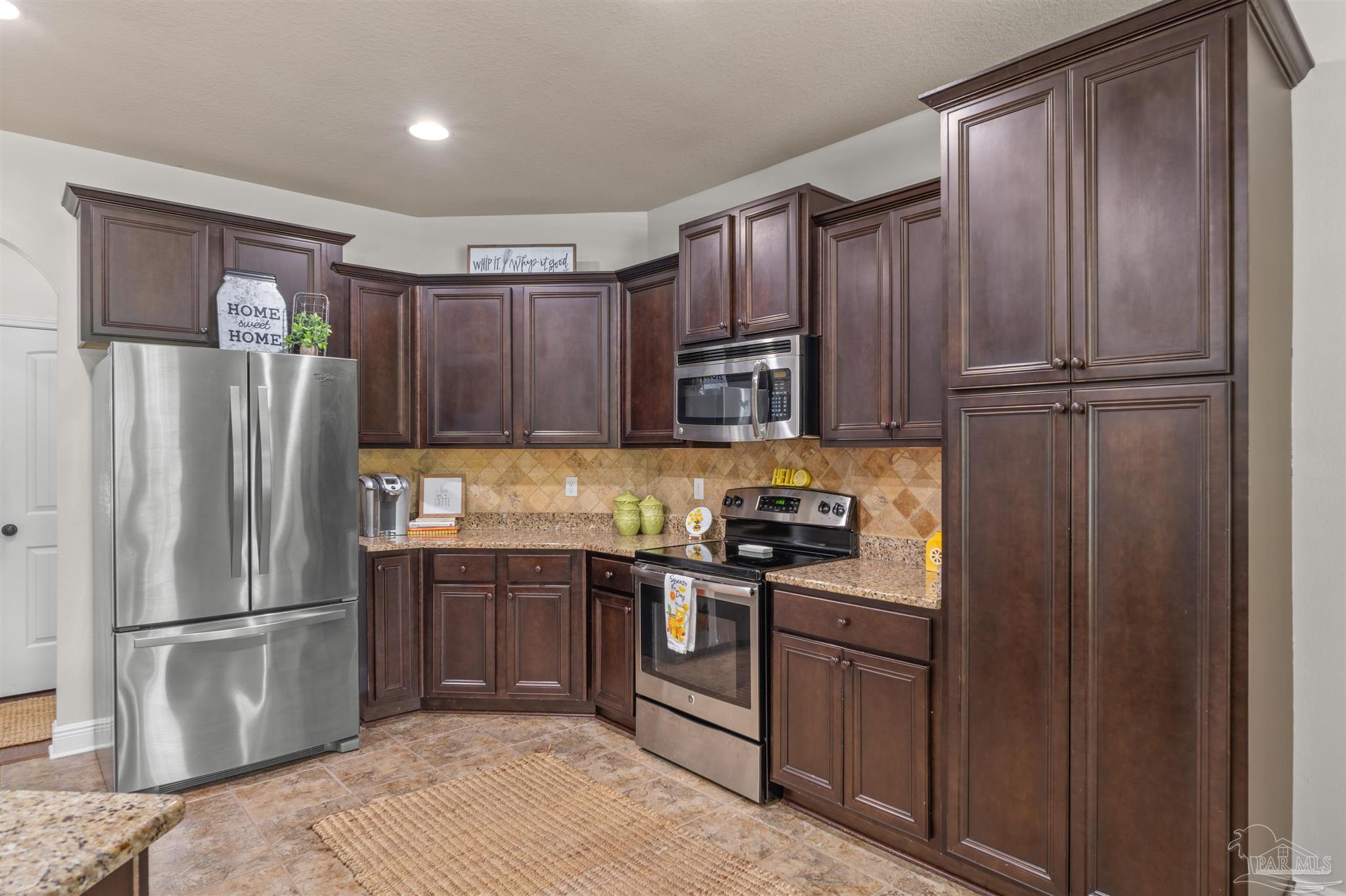 2698 Tulip Hill Road Pace, FL 32571 - Photo 33 of 65 a kitchen with stainless steel appliances granite countertop a refrigerator stove and sink